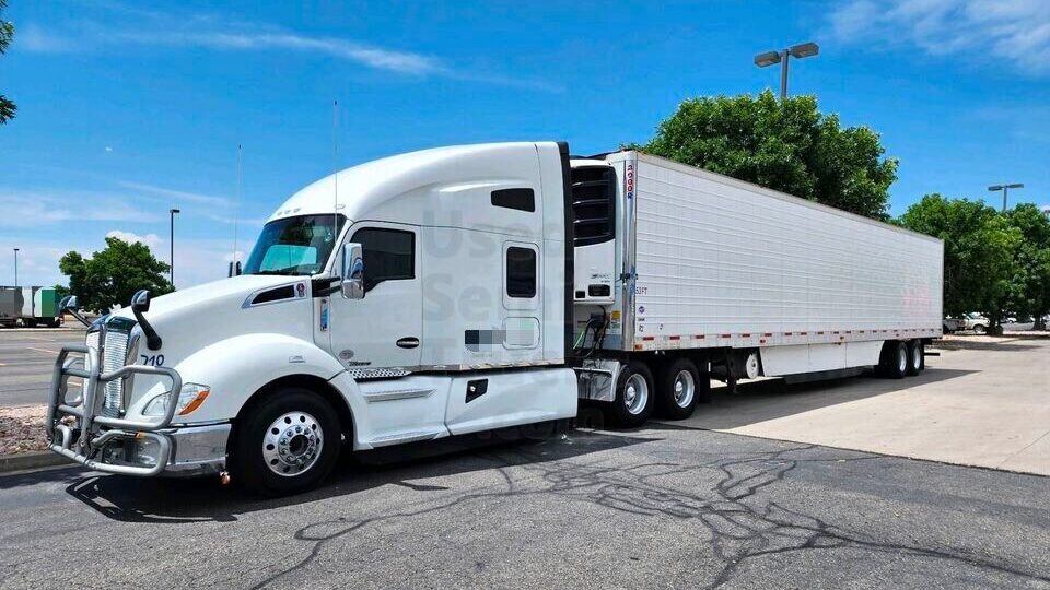 A white 2020 Kenworth T680 sleeper truck with trailer